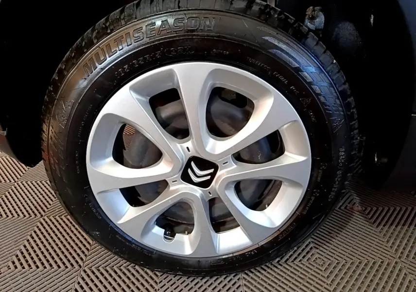 Gros plan sur la roue avant droite de la Citroën C3 blanche, avec jante argentée et logo Citroën central.