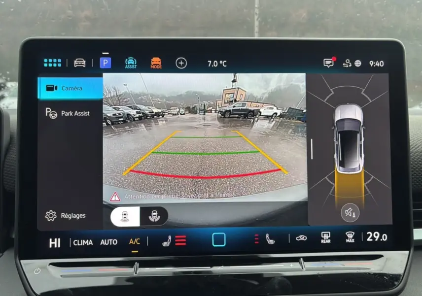 Écran de caméra de recul du Volkswagen T-Roc gris loup, affichant l'aide au stationnement sous la pluie.