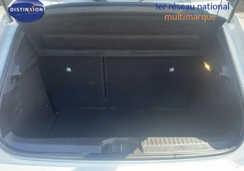 Coffre ouvert d'une Renault Clio blanche 2025, vue arrière, montrant l'espace de chargement vide et l'intérieur sombre.