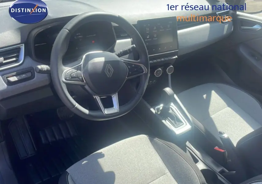 Vue intérieure de face de la Renault Clio blanche 2025, montrant le volant multifonction et l’écran tactile central.