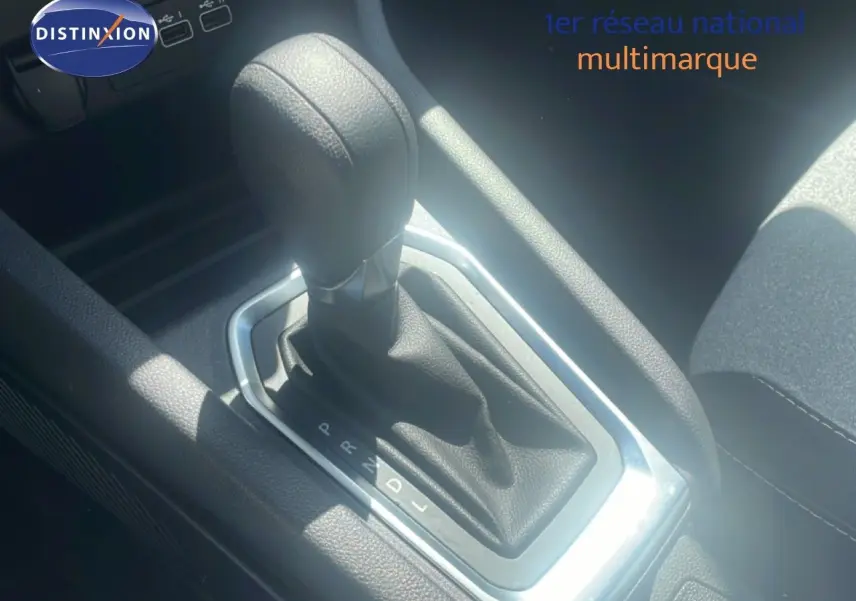 Gros plan sur le levier de vitesse automatique noir de la Renault Clio blanche, version 2025, intérieur tissu noir.