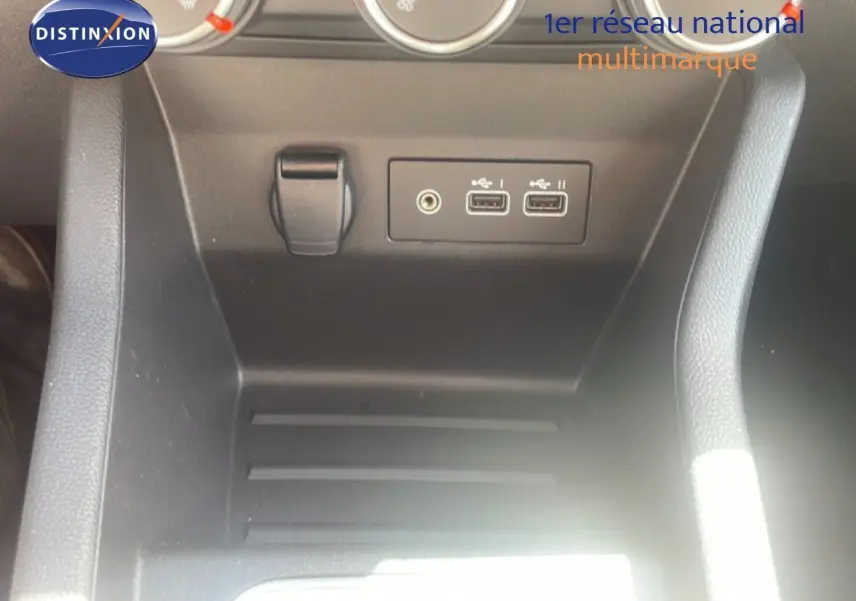 Gros plan sur la console centrale noire de la Renault Clio 2025 montrant deux ports USB et une prise jack audio.