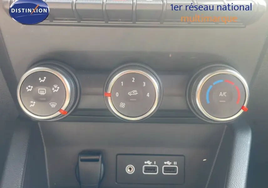 Détail du tableau de bord de la Renault Clio blanche 2025, montrant les commandes de climatisation et ports USB.