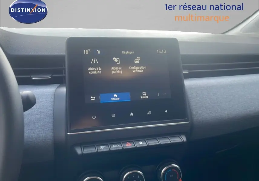 Vue intérieure du tableau de bord de la Renault Clio blanche 2025, avec écran tactile et commandes de climatisation visibles.