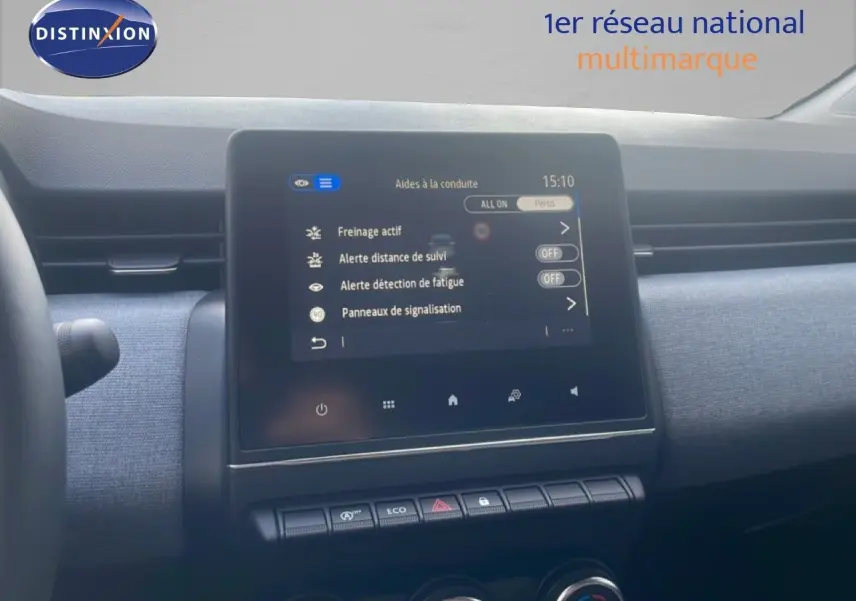 Écran tactile central de la Renault Clio 2025 montrant les aides à la conduite, avec tableau de bord gris et volant partiel.