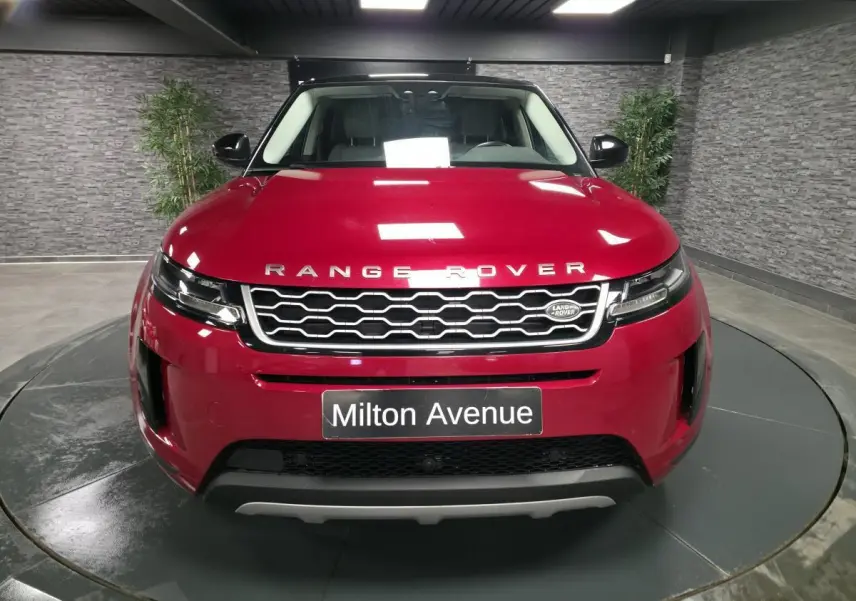 Vue avant d'un Range Rover Evoque rouge métallisé 2019 avec calandre hexagonale et logo Land Rover visible.