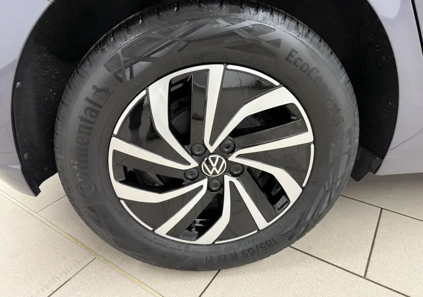 Gros plan sur la jante alliage 15'' bicolore noir et argentée d'une Volkswagen Polo gris cendre, pneu Continental EcoContact.