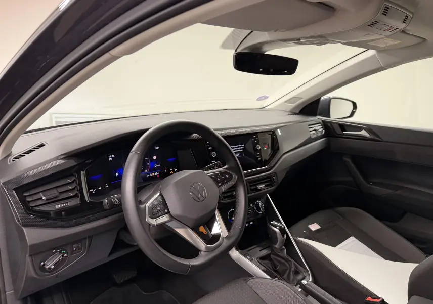 Vue intérieure côté conducteur de la Volkswagen Polo gris cendre, volant cuir multifonctions et tableau de bord digital.