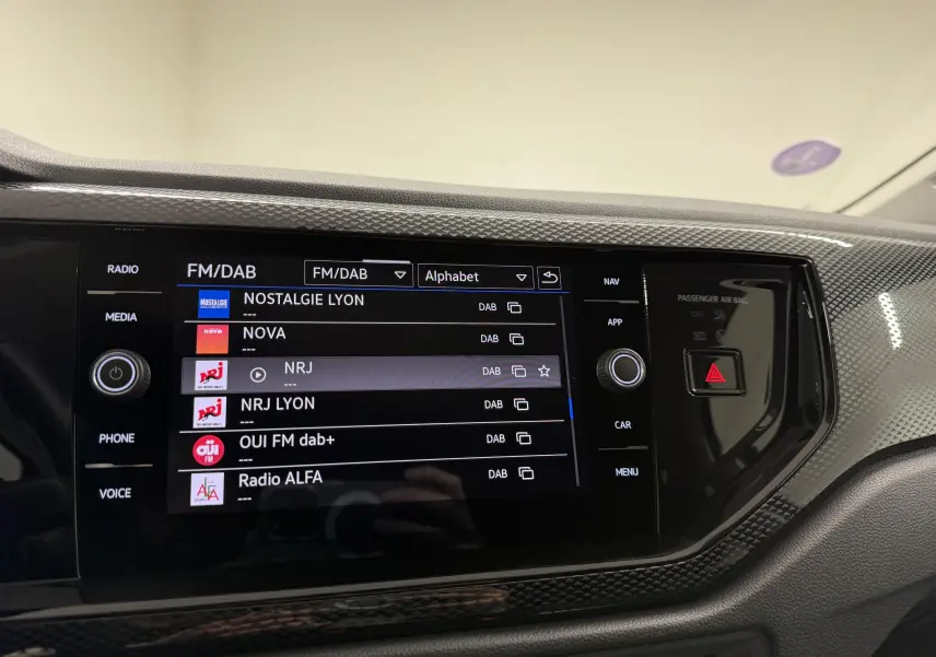 Vue rapprochée de l'écran tactile multimédia noir de la Volkswagen Polo 2025 avec interface radio FM/DAB affichée.