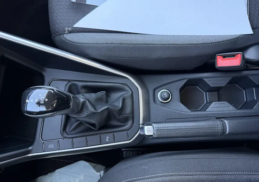 Vue rapprochée de la console centrale de la Volkswagen Polo 2025, avec levier de vitesses automatique et frein à main en cuir noir.