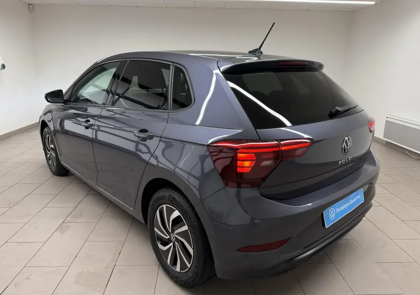 Vue 3/4 arrière droite d'une Volkswagen Polo gris cendre avec vitres surteintées et jantes alliage distinctives.