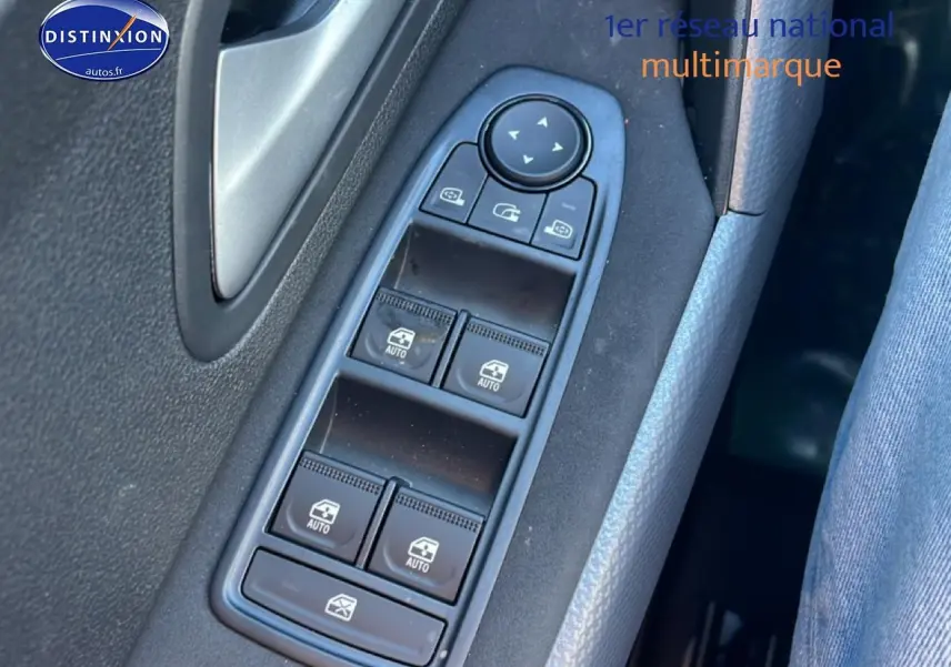 Gros plan sur les commandes des vitres électriques côté gauche d'un Dacia Duster noir, intérieur tissu gris.