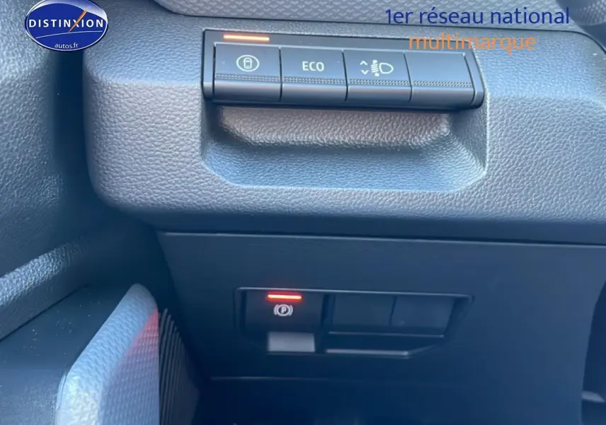 Gros plan sur les commandes du tableau de bord côté gauche du Dacia Duster noir 2026, avec bouton Eco et frein à main électrique.