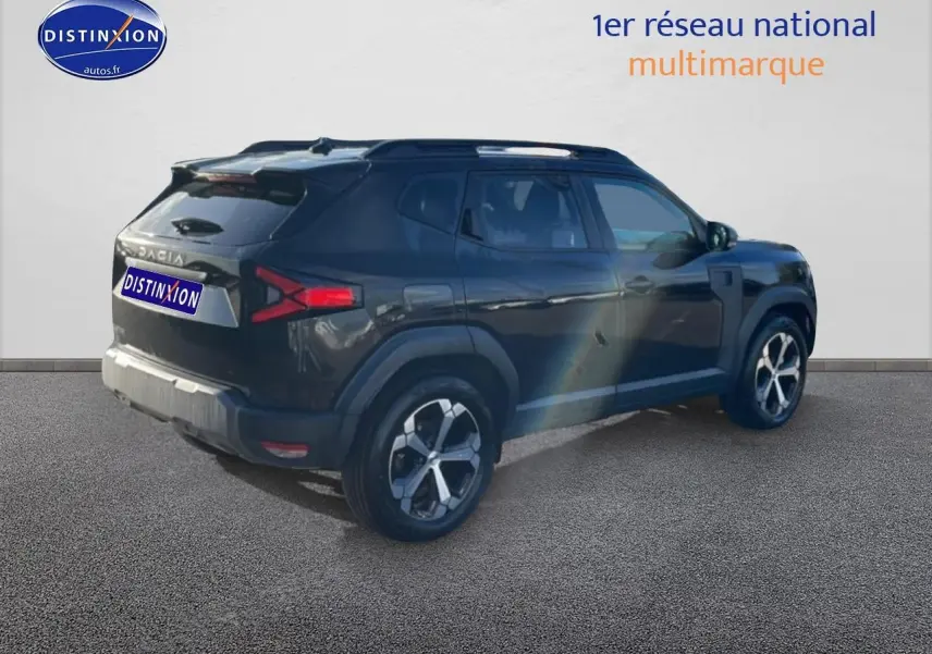Vue 3/4 arrière droit du Dacia Duster noir 2026 avec jantes alu et barres de toit visibles.