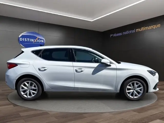 Vue latérale droite d'une SEAT Leon blanche 2025, finition Style XL, en intérieur showroom avec éclairage doux.