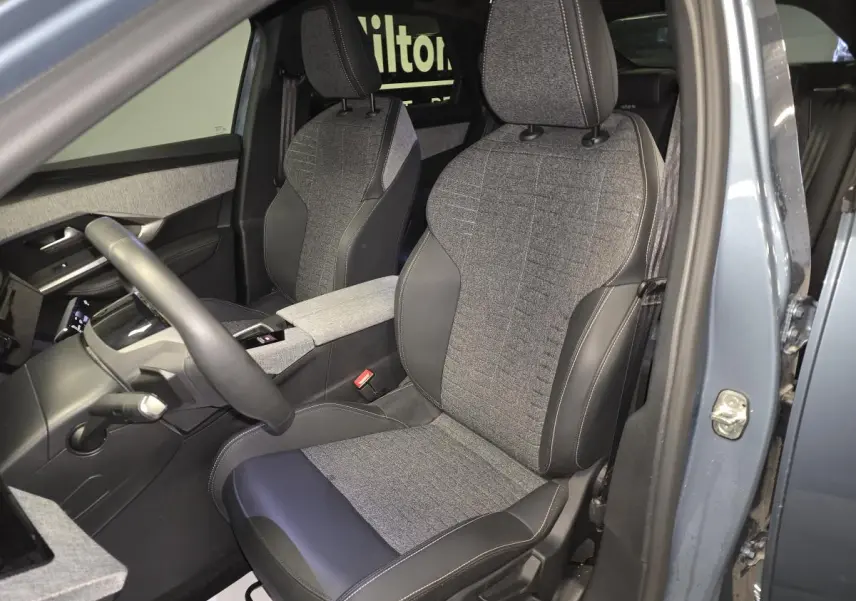 Vue intérieure côté conducteur du Peugeot 3008 2025 bleu, sièges tissu gris et cuir noir avec surpiqûres quartz.