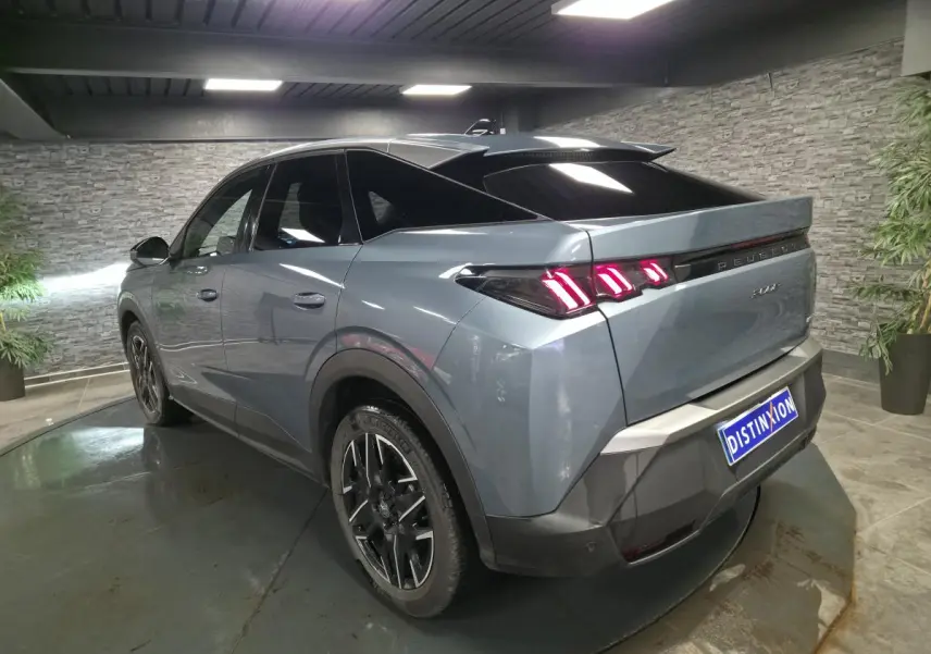 Vue 3/4 arrière droite d’un Peugeot 3008 bleu métallisé avec feux arrière à LED en forme de griffes et jantes alliage noires.