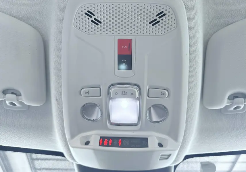 Vue en gros plan du plafonnier intérieur blanc avec boutons SOS et éclairage d'une Citroën C4 2023.