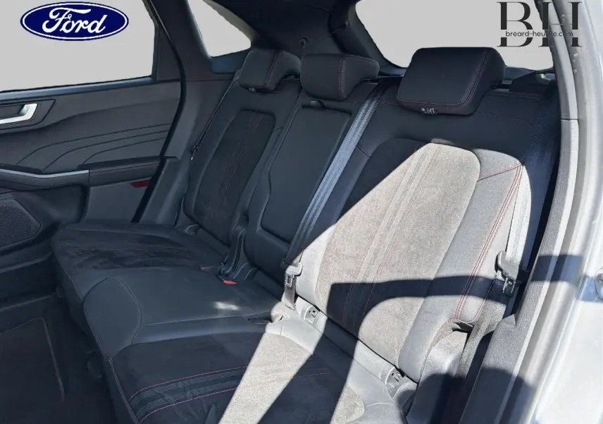 Vue intérieure de la banquette arrière du Ford Kuga 2024, sièges en suédine noire avec surpiqûres rouges.
