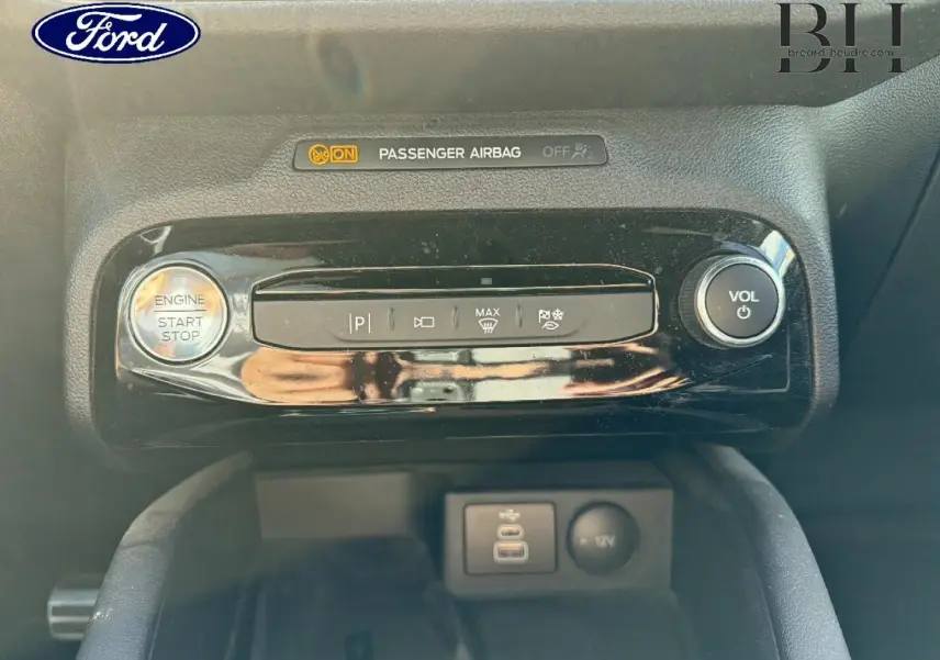 Gros plan sur la console centrale du Ford Kuga 2024, boutons de démarrage, volume et ports USB visibles.