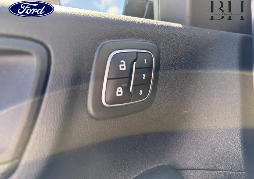 Détail du panneau de commandes de verrouillage sur la porte intérieure d'un Ford Kuga 2024 gris Solar Métallisé.