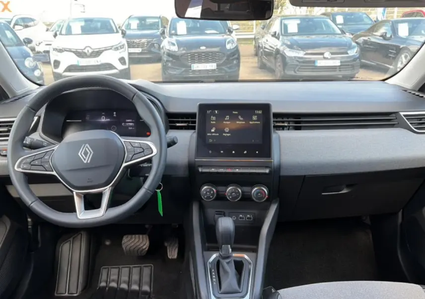Vue intérieure avant de la Renault Clio V 1.0 TCe 90 Evolution, tableau de bord gris avec écran tactile et volant multifonction.