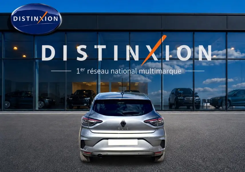 Vue arrière d'une Renault Clio V gris foncé garée devant une vitrine avec logo Distinxion.