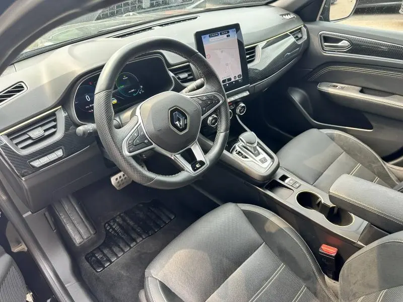 Intérieur de la Renault Arkana 1.6 E-Tech 145ch hybride, vue côté conducteur montrant volant multifonction et écran tactile vertical.