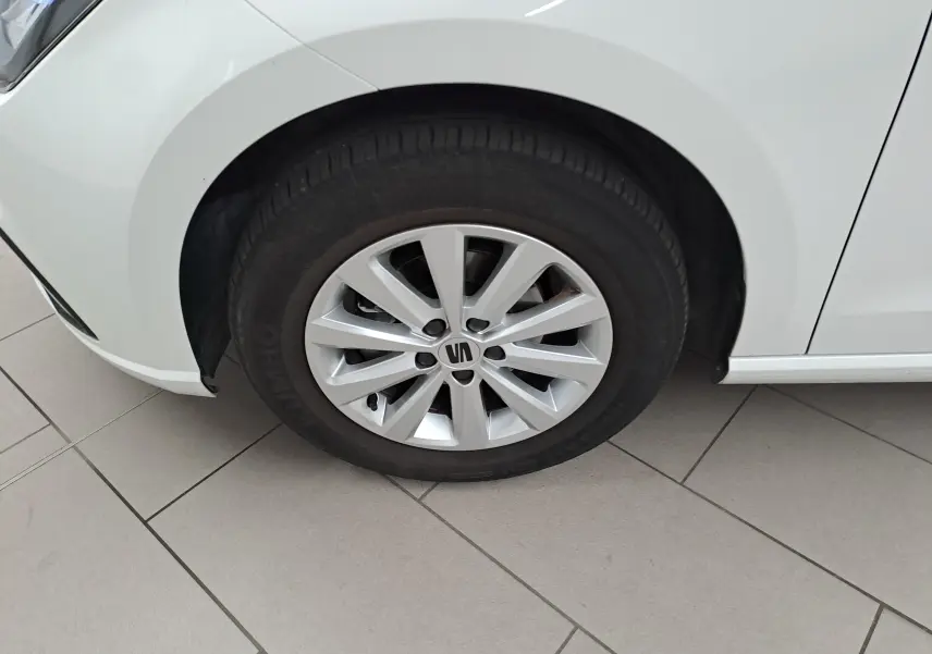 Gros plan sur la roue avant gauche d'une SEAT Ibiza blanc candy 2023 avec jante alliage et pneu Dunlop.