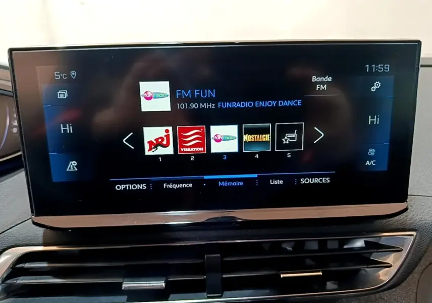 Écran tactile central du tableau de bord du Peugeot 3008 gris foncé affichant les stations radio FM.