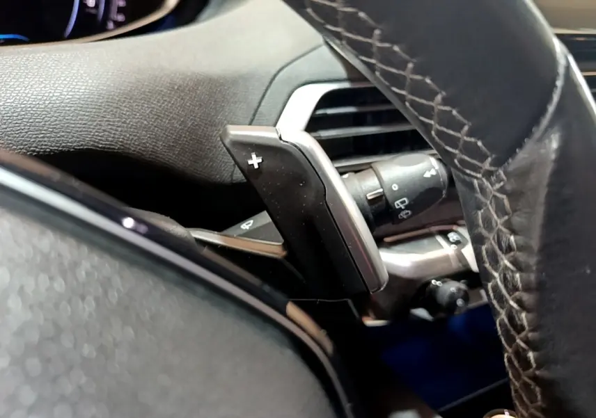 Gros plan sur la palette de changement de vitesse côté gauche du volant cuir du Peugeot 3008 gris foncé 2022.