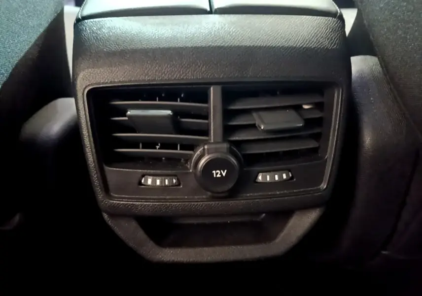 Gros plan sur la prise 12V et les bouches d'aération arrière noires du Peugeot 3008 gris foncé, version 2022.