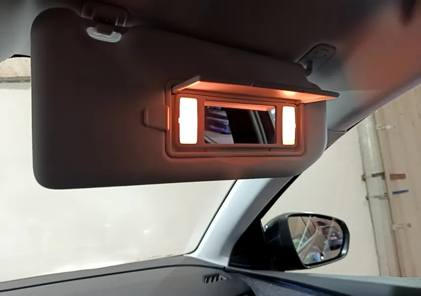 Miroir de courtoisie éclairé sur pare-soleil côté conducteur dans l'habitacle du Peugeot 3008 gris foncé 2022.
