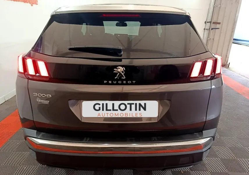 Vue arrière d'un Peugeot 3008 gris foncé avec feux LED caractéristiques et logo central sur hayon noir brillant.