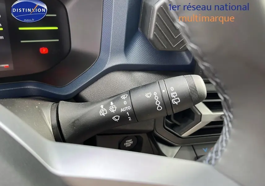 Gros plan sur la commande d’essuie-glace du tableau de bord bleu et noir du Dacia Duster gris schiste 2025.