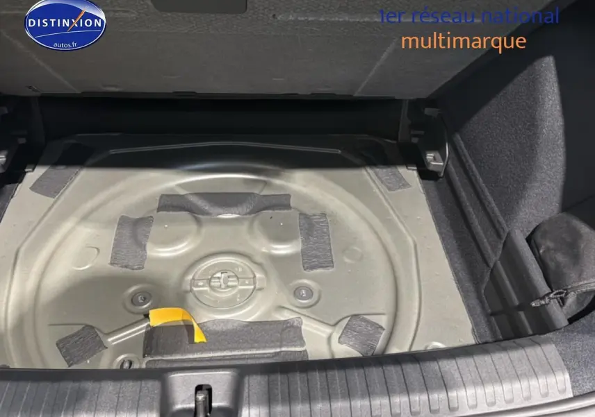 Vue plongeante sur le coffre ouvert d'une CUPRA TERRAMAR gris, montrant le compartiment à roue de secours vide.