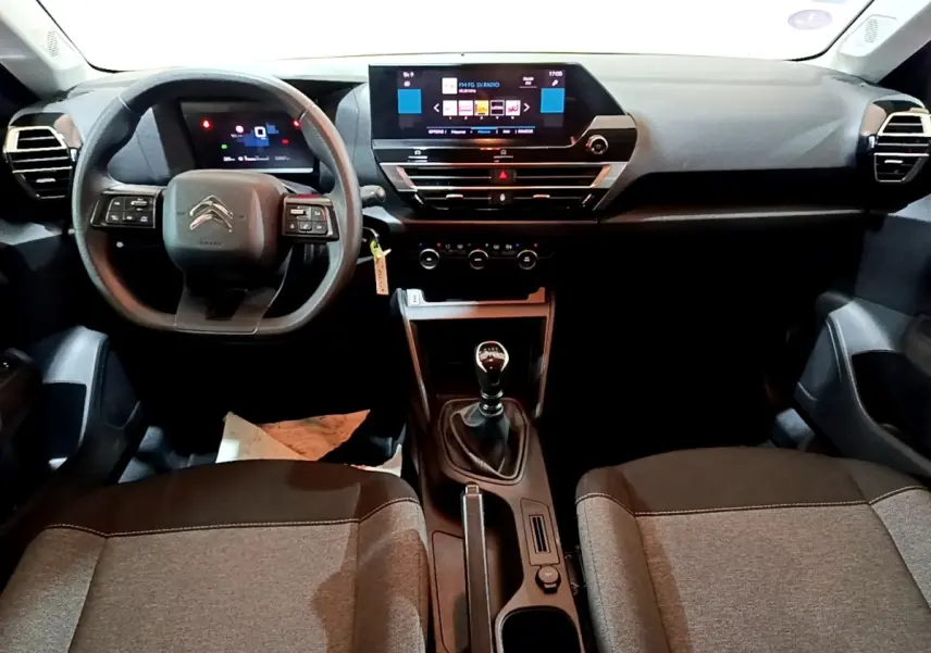 Vue intérieure avant de la Citroën C4 2021, tableau de bord noir avec écran tactile 10 pouces et boîte manuelle.