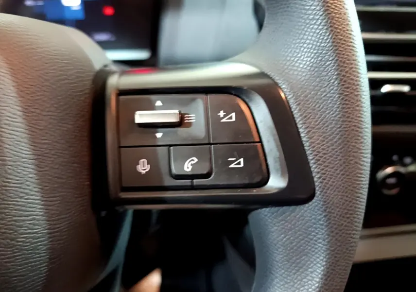 Gros plan sur les commandes multifonctions du volant en cuir noir de la Citroën C4 2021, côté gauche.