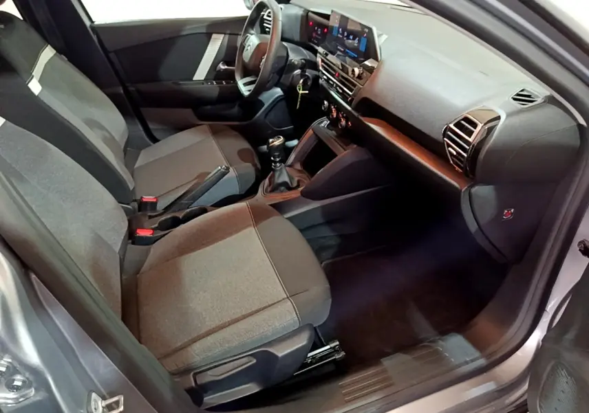 Vue intérieure côté conducteur de la Citroën C4 gris foncé 2021, avec tableau de bord moderne et sièges tissu gris.