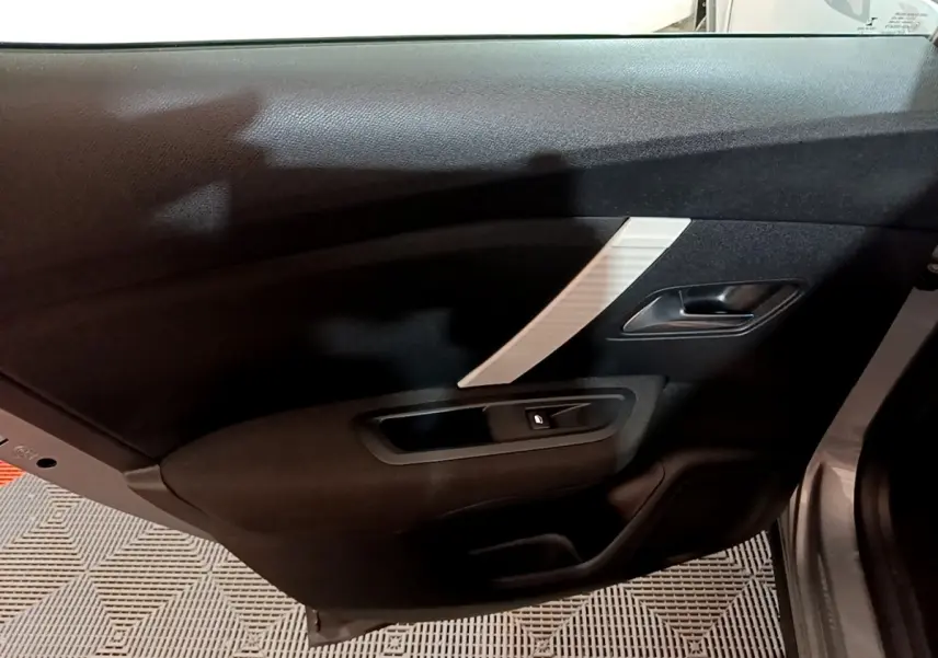 Vue intérieure du panneau de porte arrière droite de la Citroën C4 gris foncé avec poignée et bouton de verrouillage.