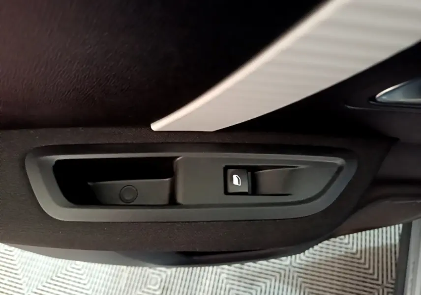 Poignée intérieure de porte arrière côté droit de Citroën C4 gris foncé, avec bouton de verrouillage.