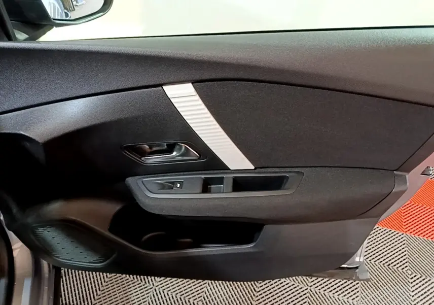 Intérieur de la porte avant gauche d'une Citroën C4 gris foncé, avec poignée noire et insert décoratif argenté.