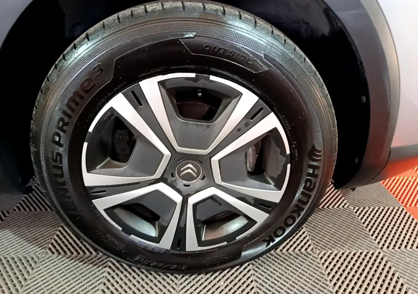 Gros plan sur la roue avant droite gris foncé de la Citroën C4 avec jante au design moderne bicolore.