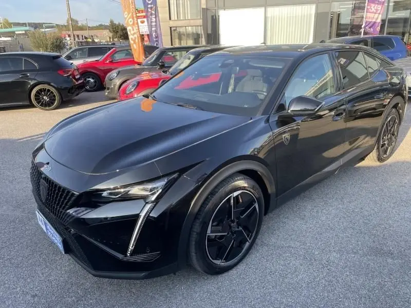 Peugeot 408 Hybrid 136 cv GT noir métal vue 3/4 avant droit avec jantes noires et détails sportifs visibles.