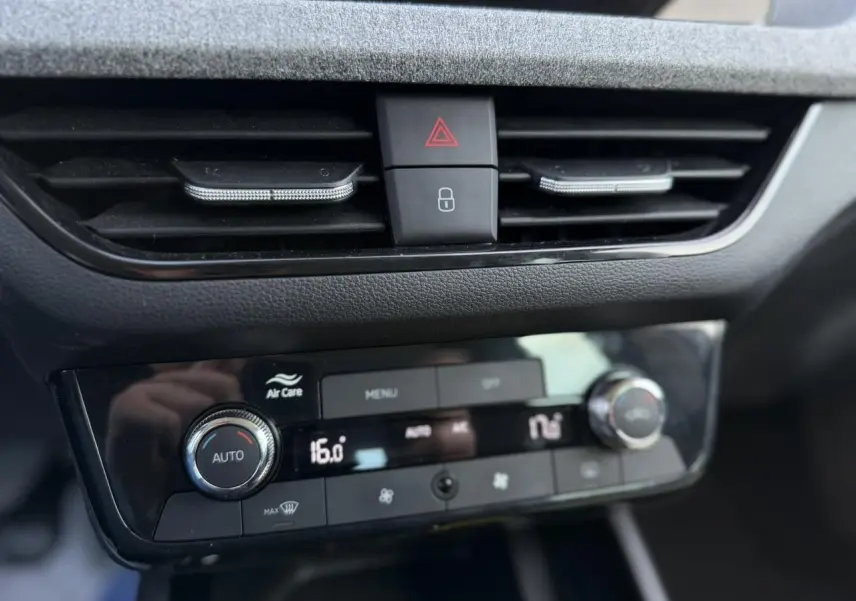 Détail du tableau de bord de la Skoda Scala TSI 116 blanc, montrant la climatisation automatique bi-zone avec commandes digitales.