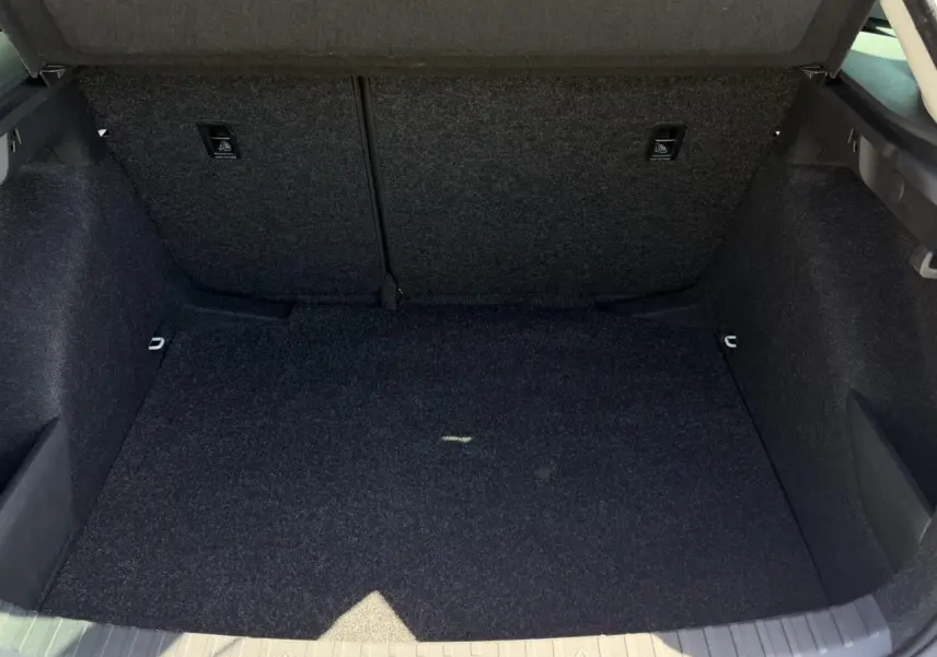 Vue intérieure du coffre spacieux et tapissé en tissu gris foncé d'une Skoda Scala Blanc Glacier 2025.