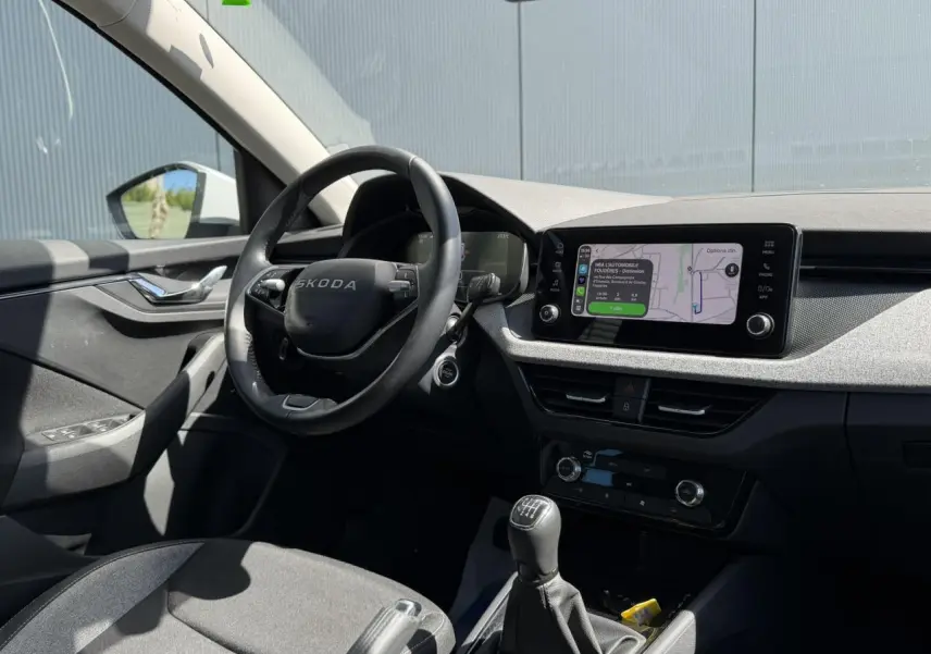 Intérieur côté conducteur de la Skoda Scala blanc glacier, volant multifonctions et écran tactile avec navigation visible.