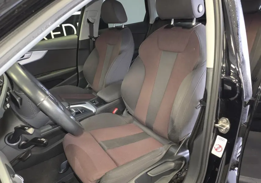 Vue intérieure côté gauche de l'Audi A4 Avant 2019 noire, sièges avant sport en tissu bicolore gris et marron.