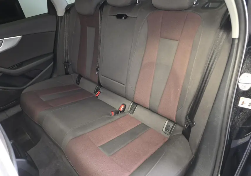 Vue intérieure côté droit des sièges arrière bicolores marron et noir d'une Audi A4 Avant noire de 2019.