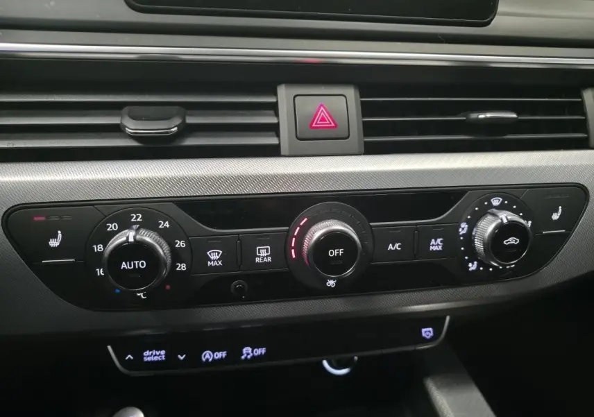 Détail du tableau de bord de l’Audi A4 2019 noir, montrant les commandes de climatisation et chauffage des sièges.